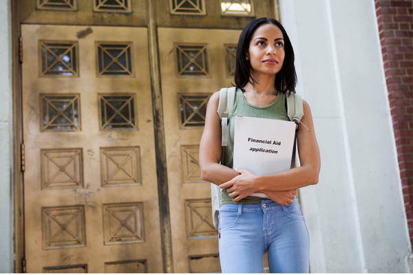 Woman standing in front of doors holding folder that says Financial Aid Appeal