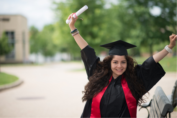 Female college graduate holding diploma with arms stretched above head in celebration